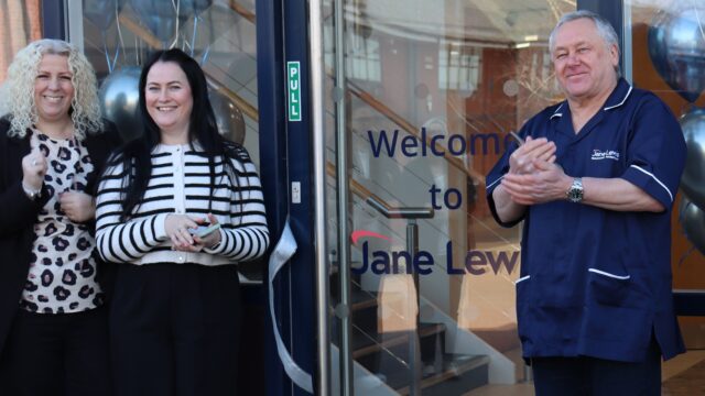 Male Jane Lewis Nurse and two female staff members, applauding at the entrance to the new Jane Lewis North Wales office