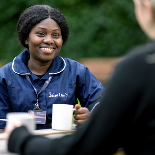 Jane Lewis Nurse sitting outside with service user drinking tea