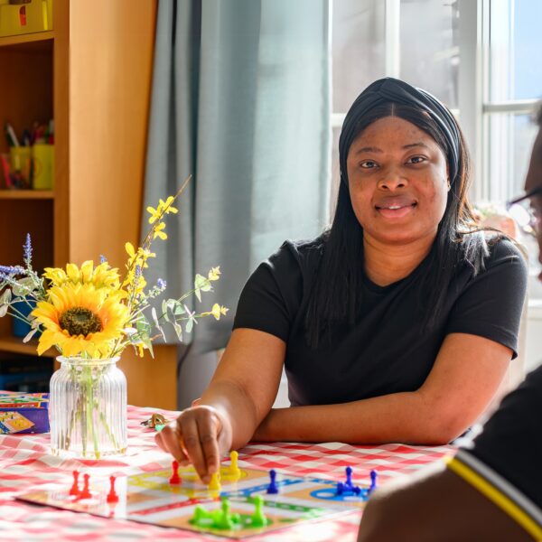 Jane Lewis Healthcare Assistant sat playing a board game with service user